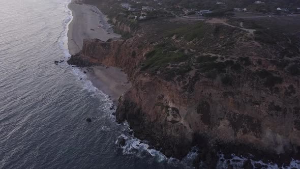 AERIAL: Flight Over Malibu, California View of Beach Shore Line Pacific Ocean at Sunset with alt