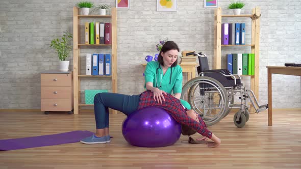 Physiotherapist in the Rehabilitation Center Helps a Teenage Girl in Rehabilitation After an Injury alt