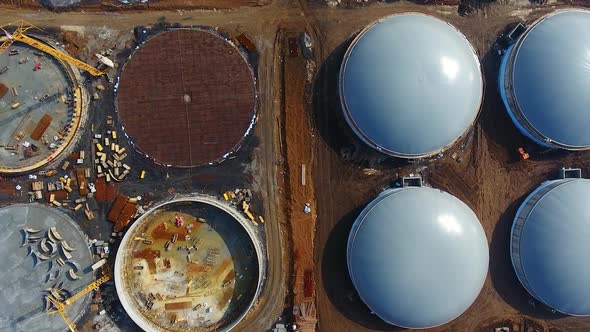 Round gray roofs on construction zone of bio gaz factory. Modern production of ecological fuel. alt