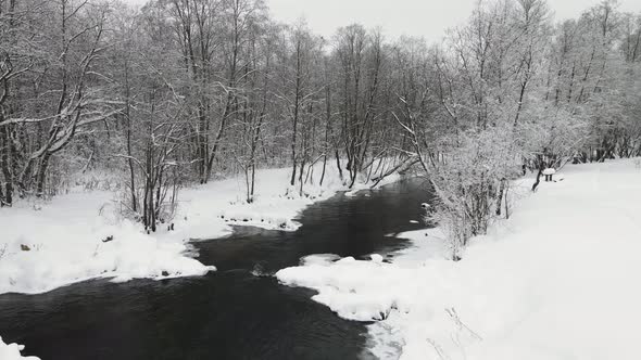 Snowy Winter Landscape with a Stormy River Aerial View alt