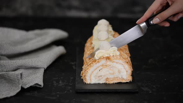 Cook Cuts Into Portions Delicious And Fresh Meringue Roll With Cream.