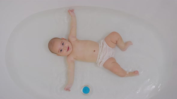 Top View of Funny Newborn Baby Swimming During Bathing. alt