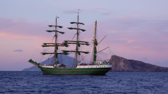 Green Sailing Ship with People on Board Floating in Sea. Lipari Islands, Sicily, Italy alt