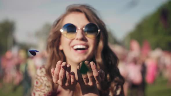 Girl blowing some confetti pieces alt