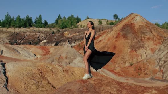 Beautiful woman posing on other-worldly hilly landscape