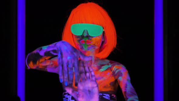 Beautiful Model Woman in Wig and Glasses with Colorful Bright Fluorescent Makeup in Neon Light