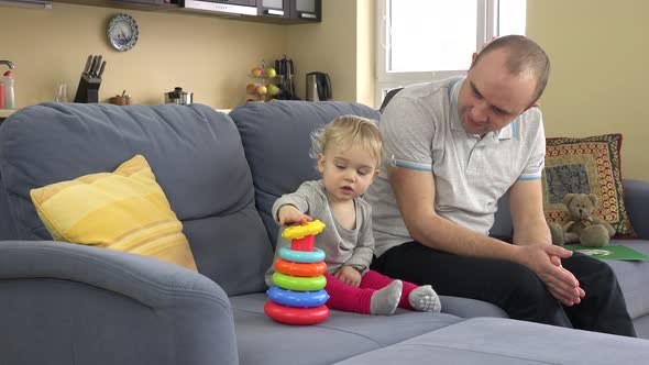 Lovely Girl And Loving Father Play Colorful Pyramid Rings