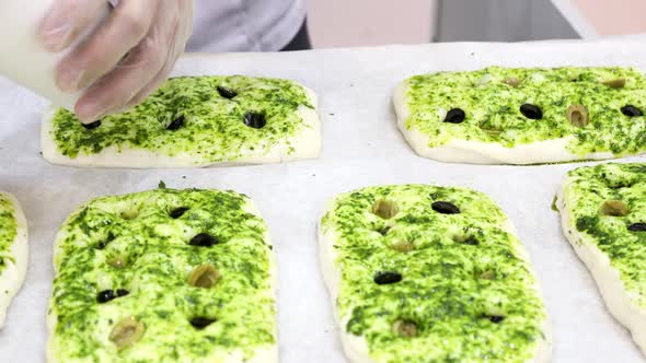 Chef Makes a Pizza and Starts It with Olives
