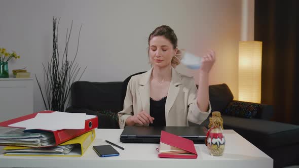 business woman girl takes off her medical face mask feels tired after hard day alt