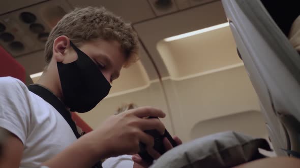 Teen in Mask on Airplane