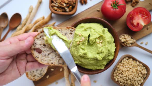 Hand Cooking Healthy Food By Spreading Avocado Smash On Toast alt