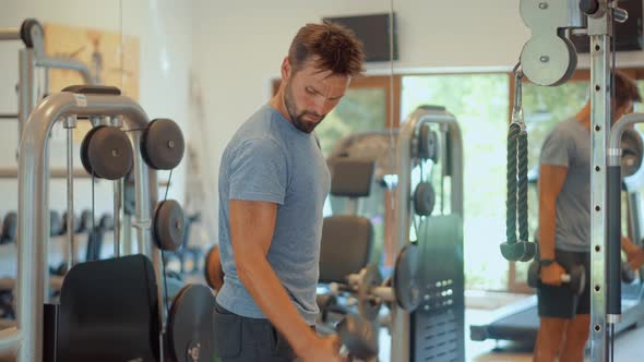 Man Weight Lifted Exercising In Gym Dumbbells. Multi-gym Workout. Fitness Exercising In Sport Gym. alt