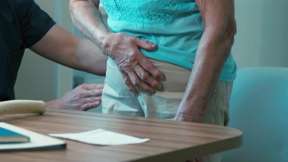 Male surgeon inspecting bone's of old patient