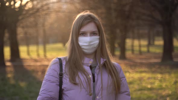 Portrait of a cute European girl in a white medical mask. 