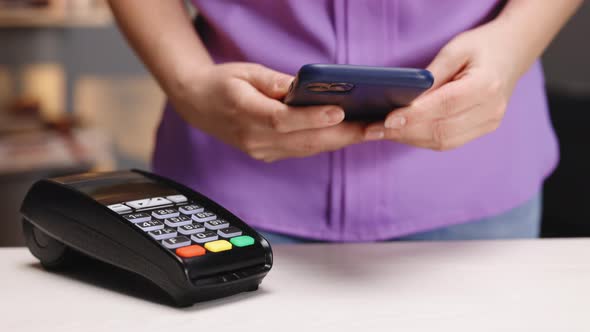 Pos-terminal in Hand of Store Worker Purchase by Cell-phone on Electronic Payment Machine