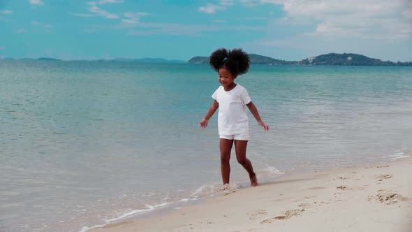 Happy African American girl enjoy and walking on the beach
