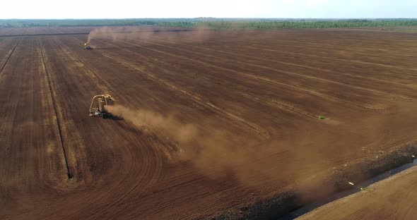 Peat Harvesting Machines Working on Field Collecting Peat Dust Aerial View alt