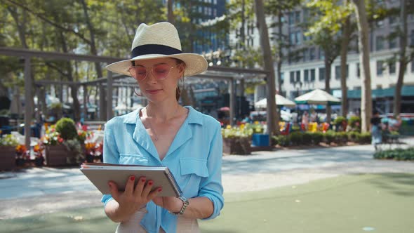 Smiling woman with a travel book in New York City alt
