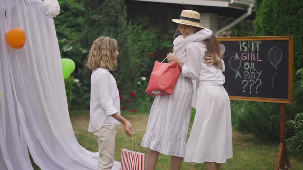Pregnant Caucasian Woman Greeting Friends Coming for Baby Shower Party alt