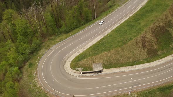 Two White Cars Drive on a Bend Along a Serpentine Mountain Road. Aerial Vertical Top View