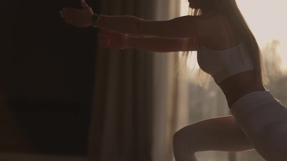 A Young Woman Exercises Performing Exercises From Yoga in Slow Motion in Sunlight alt