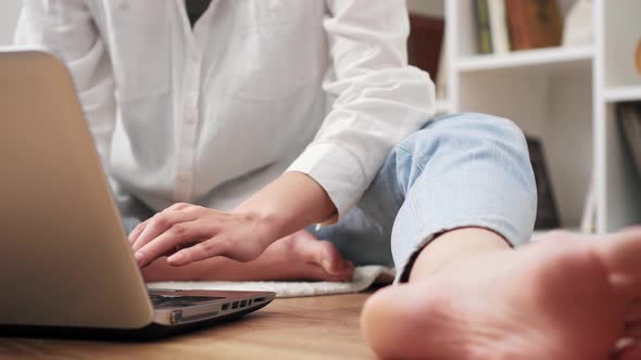 Fashionable Woman Using Laptop While Sitting On Floor. Woman Using Modern Tablet Gadget At Home alt