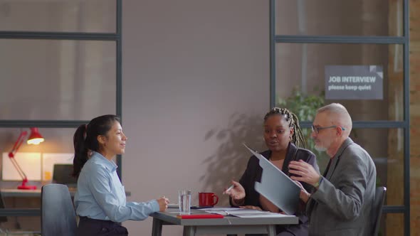 Hispanic Woman Having Job Interview with Multiethnic HR Managers alt