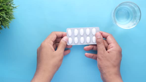 Top View of Young Man Taking Medicine Form a Blister Pack alt