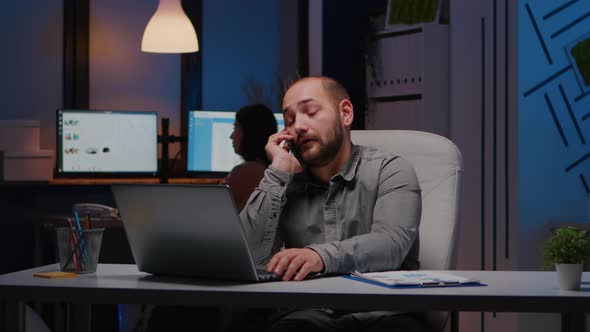 Exhausted Businessman Sitting at Desk Table Discussing Management Ideas alt