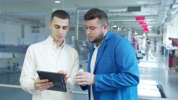 Industrial Employees with Tablet Inspecting Factory Equipment