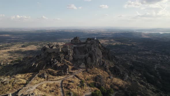 Castle of Monsanto, hilltop medieval building in Portugal, aerial pull in shot