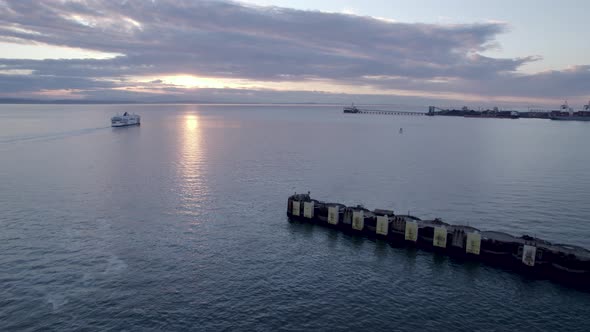 Aerial forward over Tsawwassen Vancouver terminal at sunset with ferry in background, British Columb alt