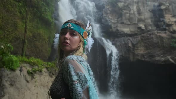 Woman Looks Like Indian Shaman in Forest with Waterfall alt