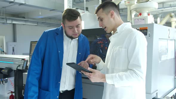 Industrial Employees with Tablet Inspecting Factory Equipment