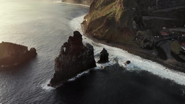 Drone flying towards massive sea stack near Ribeira Da Janela, Madeira Island Portugal
