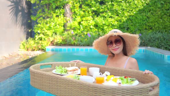 Woman with floating breakfast in pool