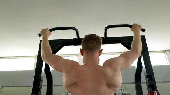 Slow Motion Shot of Male Athlete's Back As He Performs Some Pullup Exercises alt