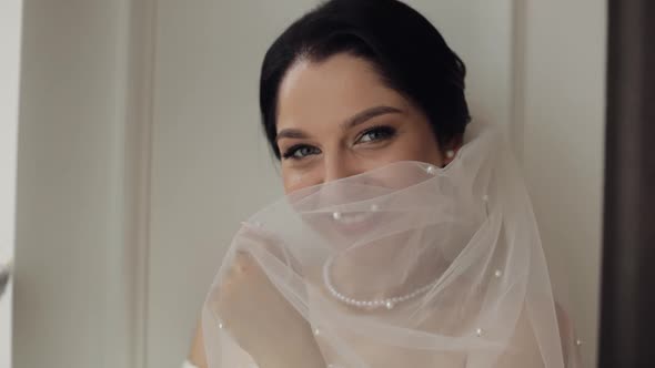 Bride in Boudoir Dress Under Veil and in a Silk Robe Wedding Morning Preparations Before Ceremony alt