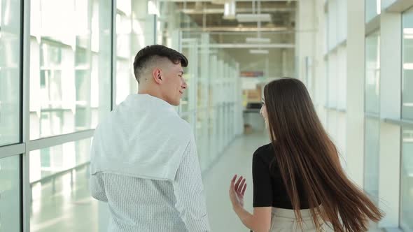 A Young Woman and a Man are Talking and Walking Through the Airport alt