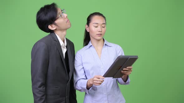 Young Asian Business Couple Getting Bad News Together