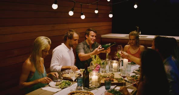 Pouring champagne at a dinner party alt
