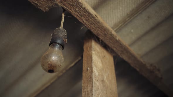 An old lamp hangs from the ceiling. Abandoned house. A spark of hope. Idea. alt