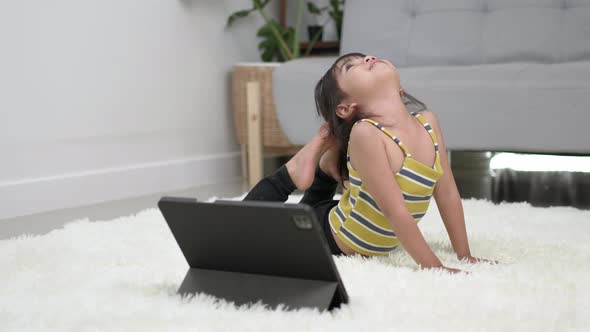 Little girl play gymnastic with bow posture at home alt