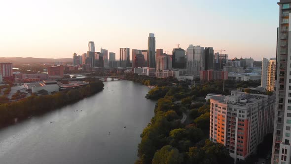 Slow rise from Rainey Street looking downtown at golden hour. Kayaks and paddle boarders can be seen alt