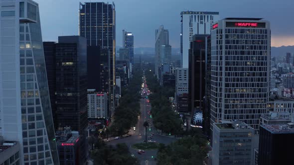 Modern Tall Buildings Along Wide Main Boulevard After Sunset alt
