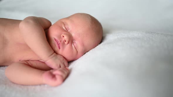 Cute emotional newborn yawning funny little baby boy sleeping in crib. Infant baby. Nursery