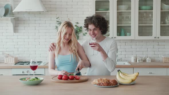 Happy Loving Young Couple Cutting Fresh Vegetable Salad Having Fun Cooking Together in Modern Cozy alt