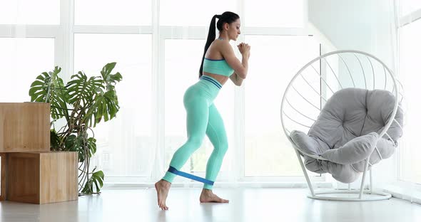Woman during her fitness workout with rubber resistance band.