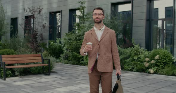 Positive Good Looking Man Glasses Carrying Bag Coffee Paper Cup alt