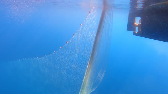 Fishing Net Hanging From Boat Under Sea in Underwater